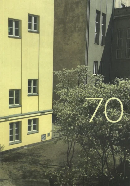 Okładka przedstawia liczbę 70 a za nią zdjęcie podwórza otoczonego budynkami i roślinnością o zróżnicowanej kolorystyce