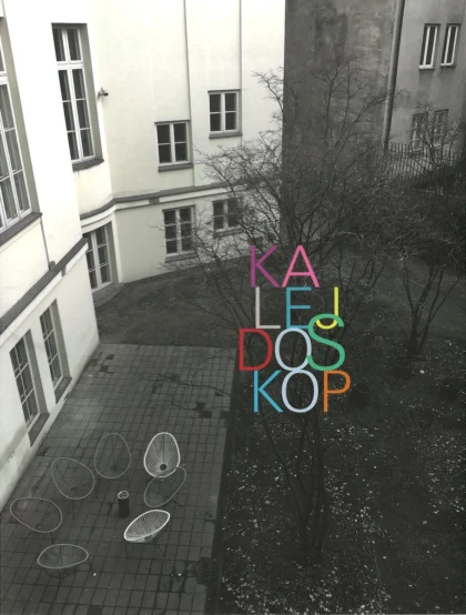 Na okładce widoczny jest gmach budynku utrzymany w odcieniach szarości oraz wielobarwny tytuł publikacji