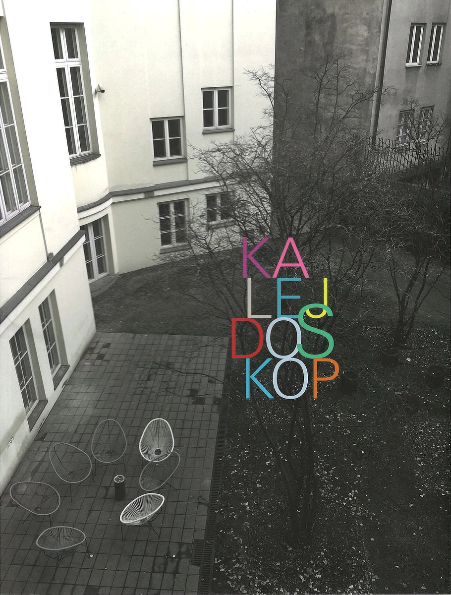 Na okładce widoczny jest gmach budynku utrzymany w odcieniach szarości oraz wielobarwny tytuł publikacji